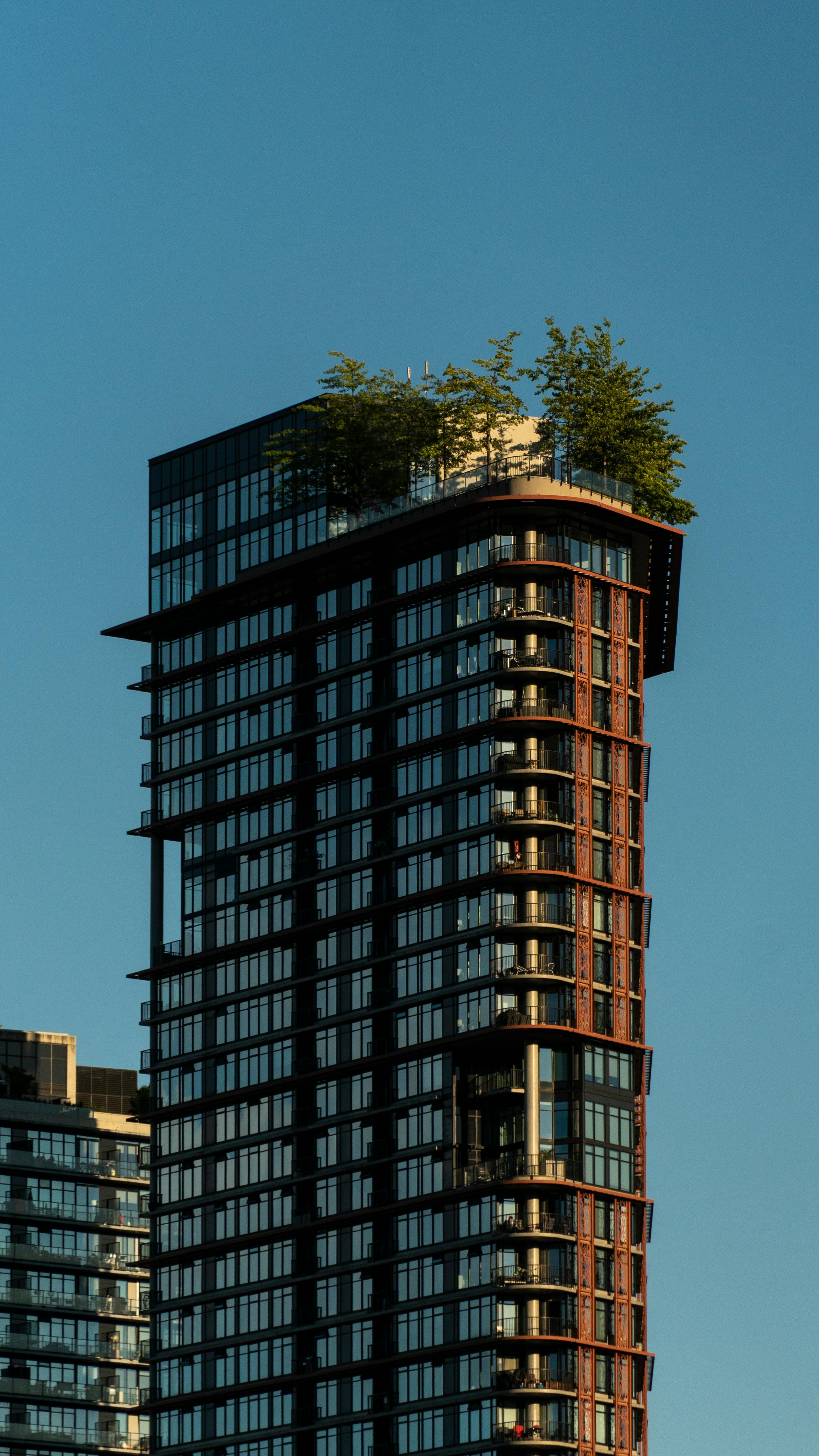 A modern Pakistani high-rise residential tower with a rooftop garden